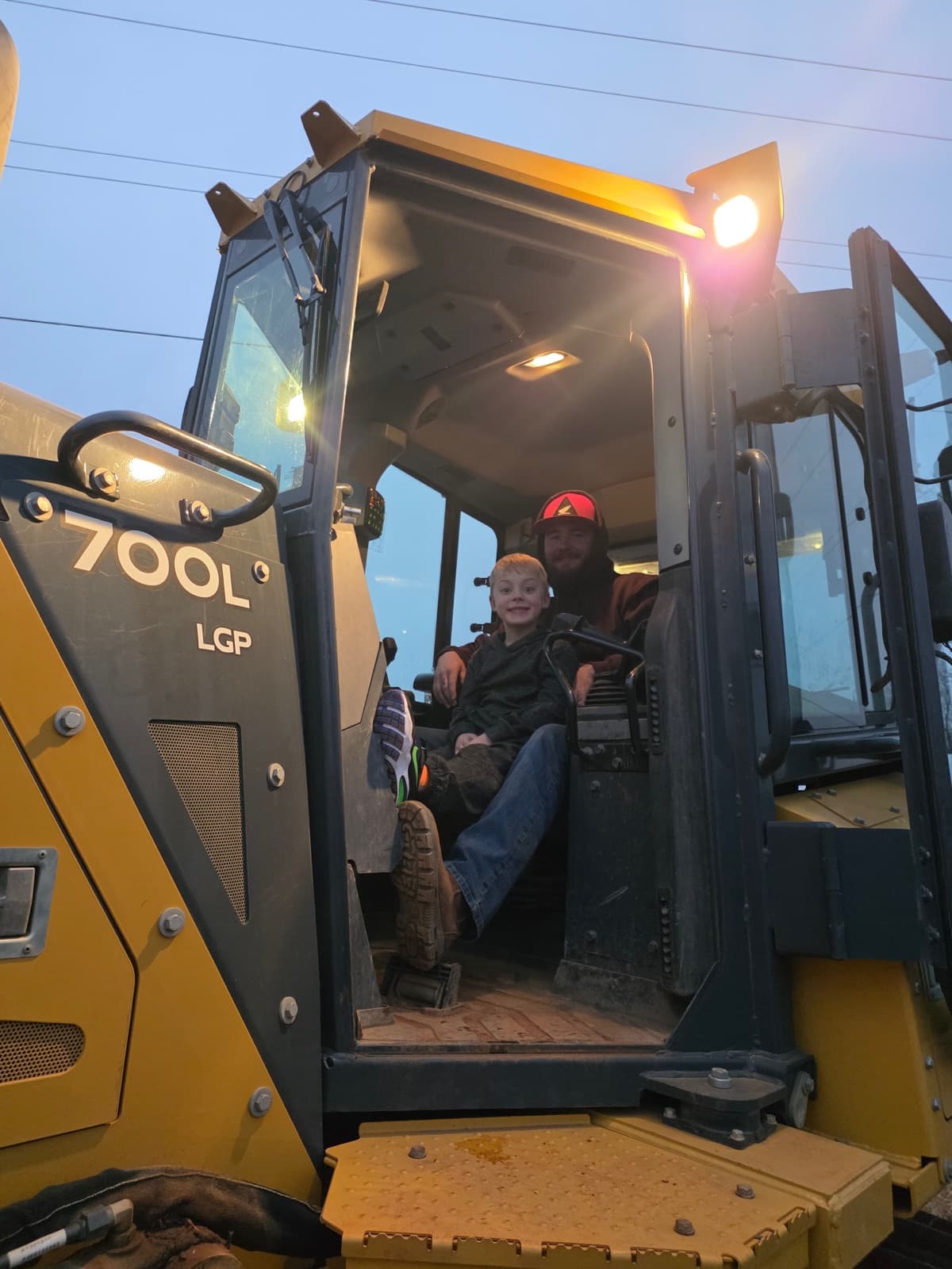 Tyler Jackson and his son Hayden in the cab of a John Deere dozer