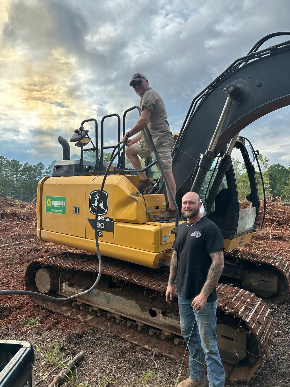 Tyler Jackson and his dad with a John Deere excavator on a clearing job