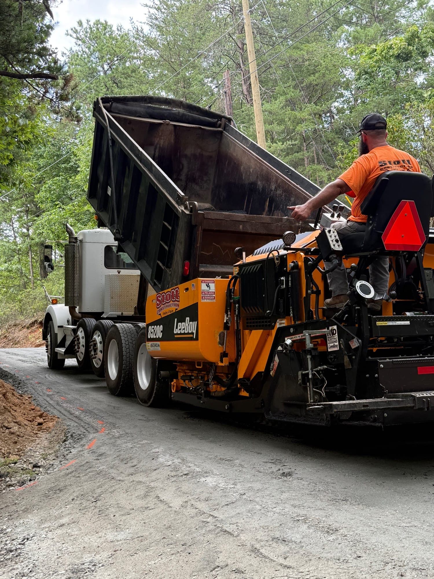 Asphalt paver laying a new drive with the TLJ dump truck ahead