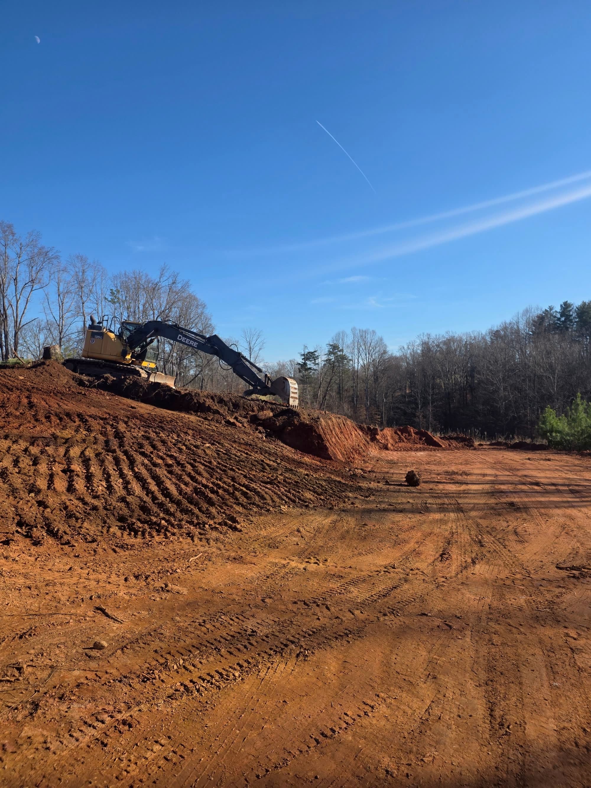 Excavator working a red clay bank