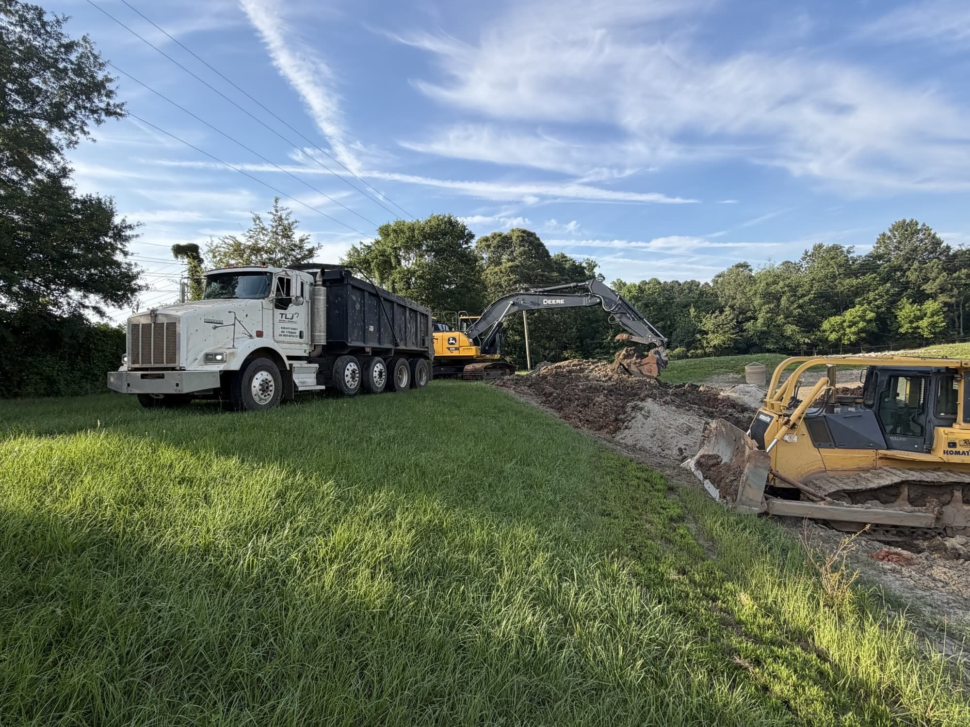 Dump truck, excavator, and dozer working a site together